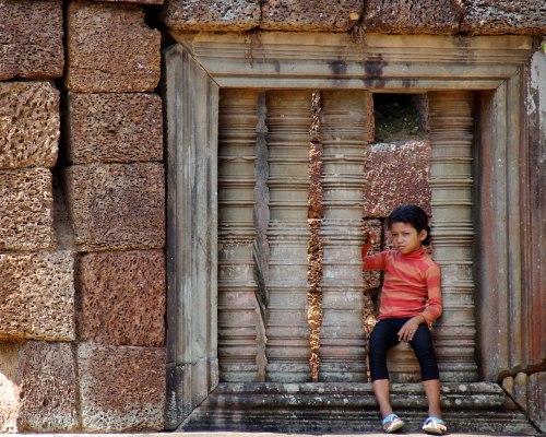 From the look on this girl's face, to the size and scale of the 'window' that's been built into the temple wall, everything in this photo is what Angkor Wat.
